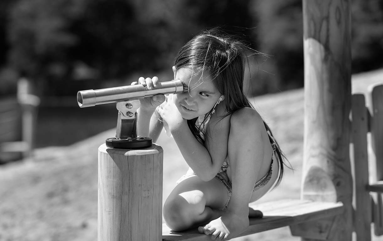 Young girl looking through a telescope