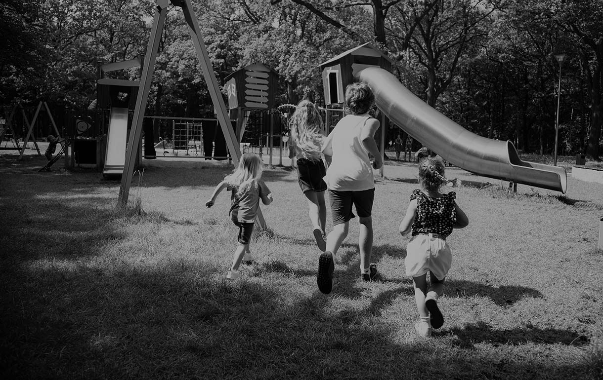 Children running towards a playground in the countryside