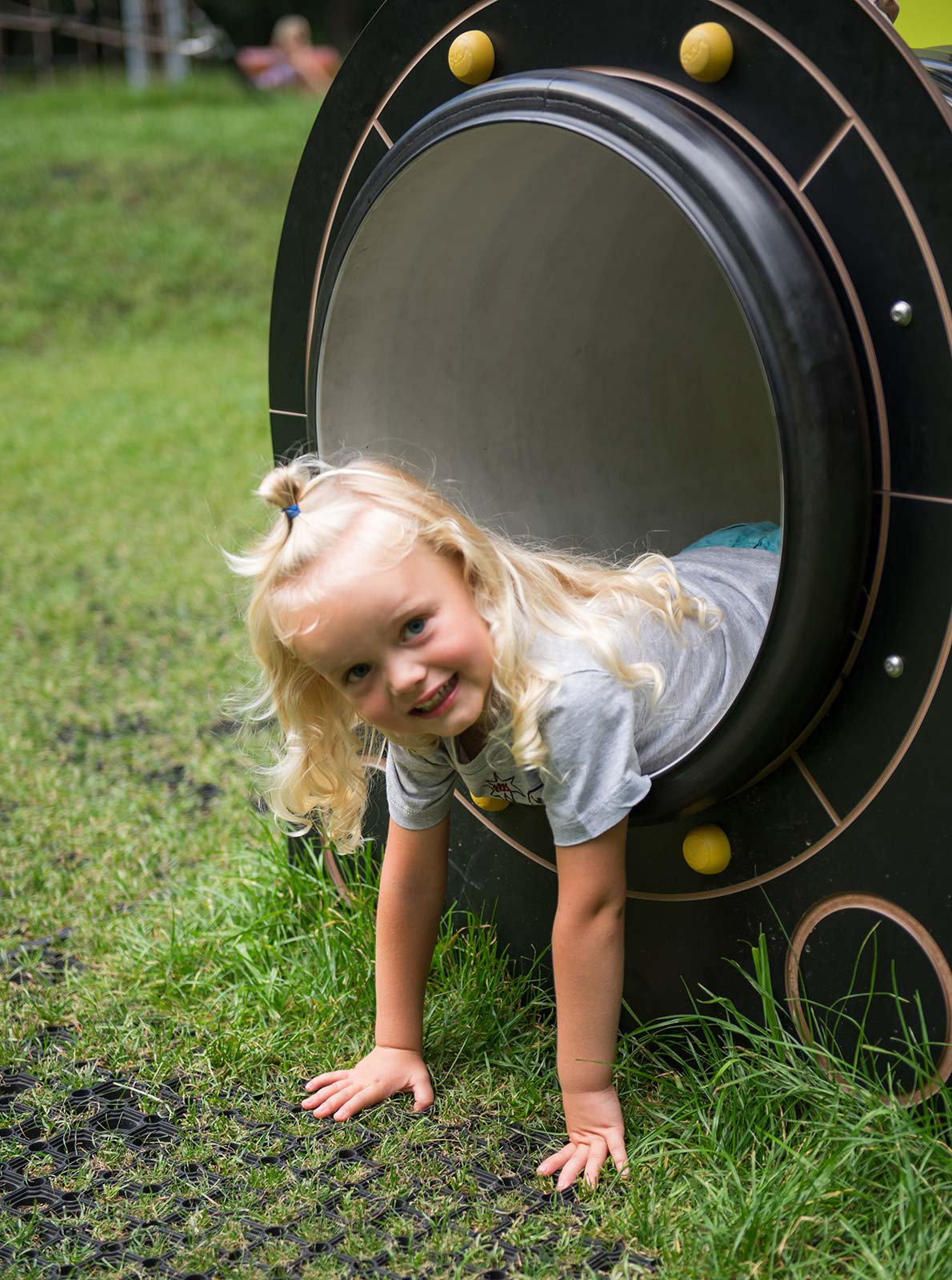 Young girl peering out of a tunnel