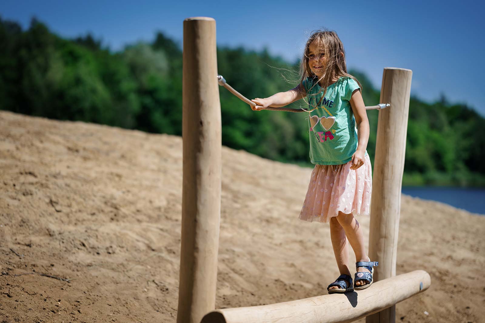 Young girl walking across a wooden frame