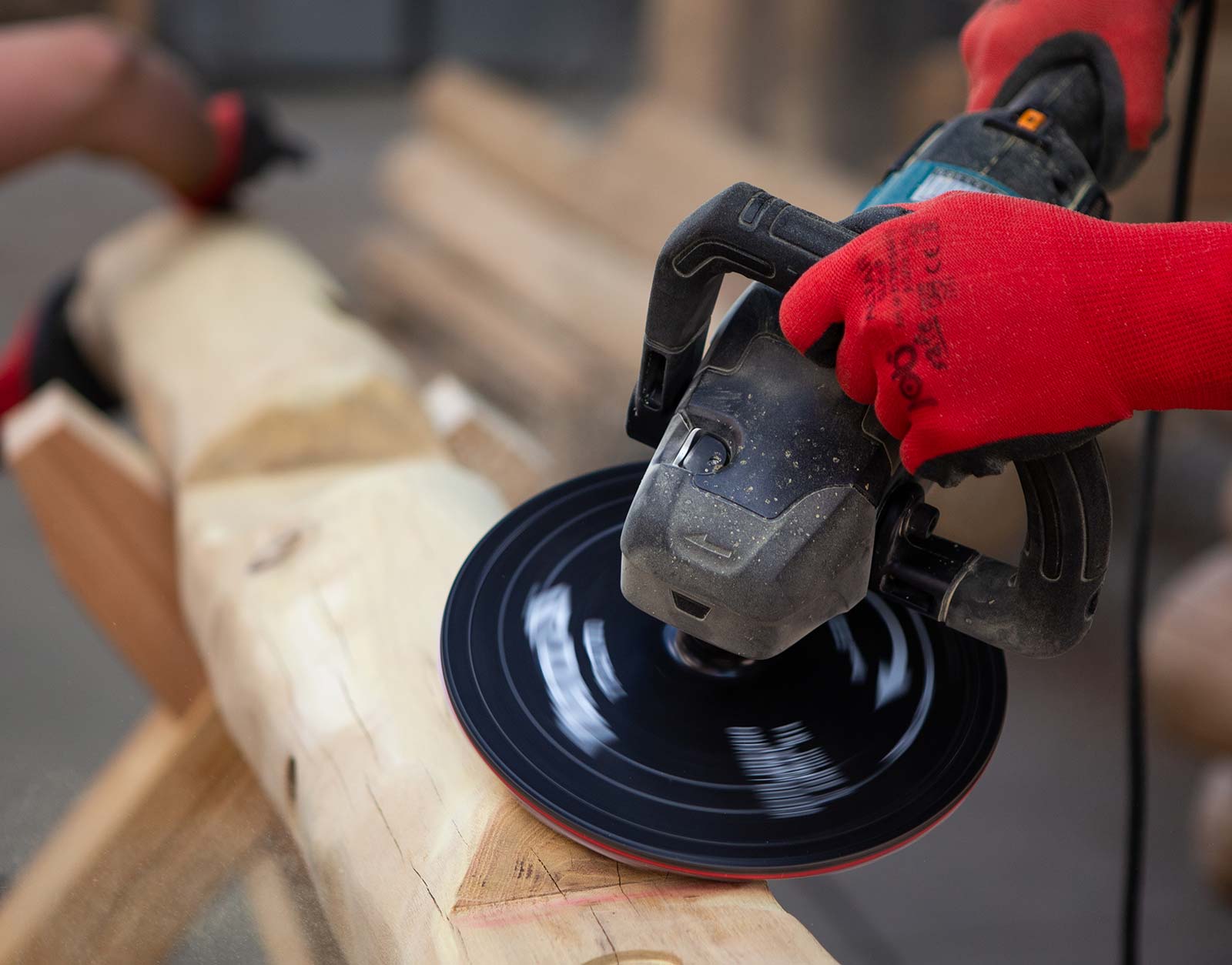 Sanding wooden post with rotary sander