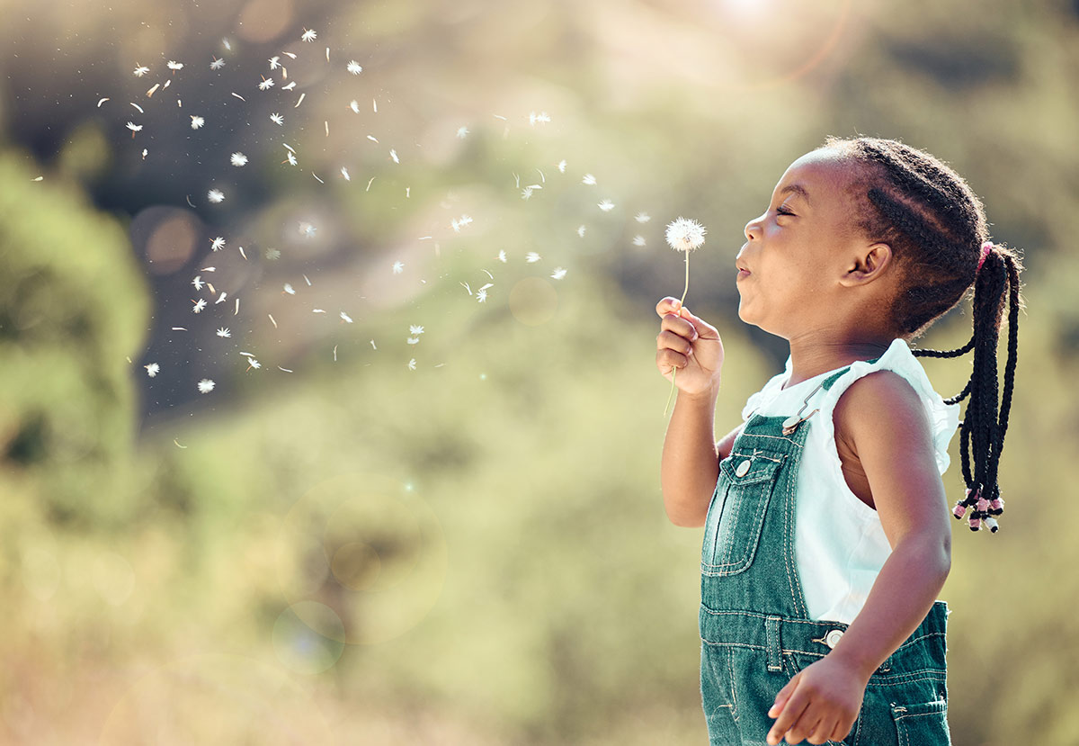 Girl blowing dandelion seeds