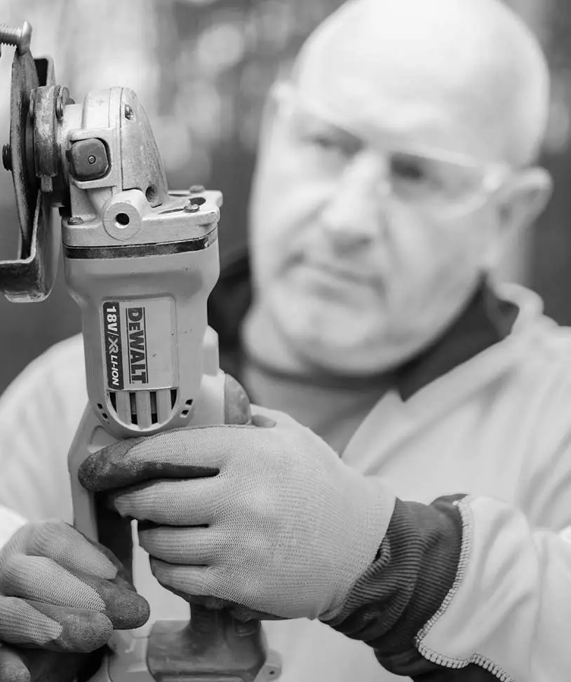 Worker carefully handling a DeWalt power tool during the manufacturing process.