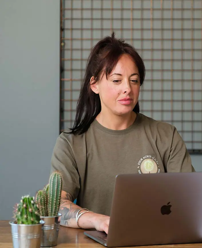 Team member sitting at a desk with a laptop, working and ready to discuss projects.