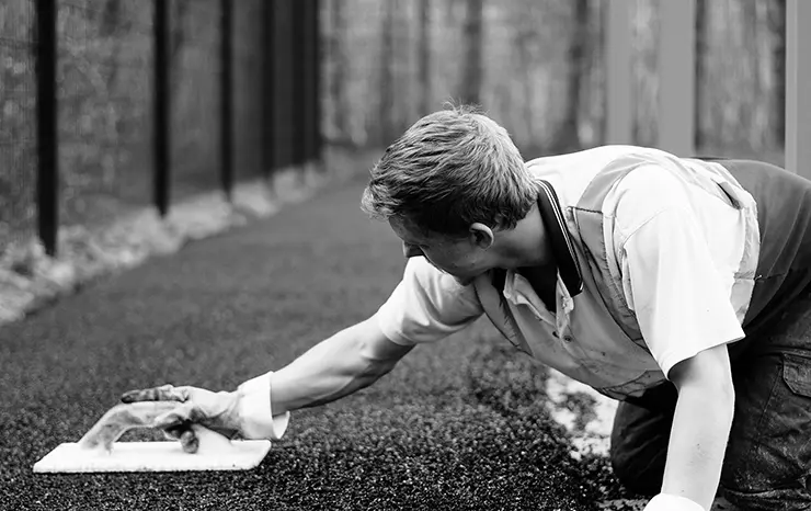 man working on soft surfaces in a playground